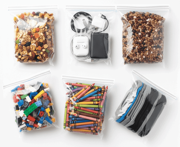 Storage bags filled with snacks, cables, crayons, and other items